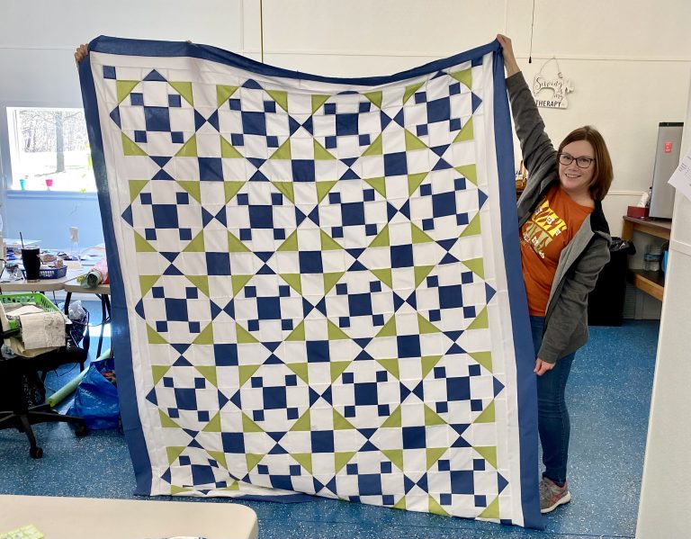 Maria holding a quilt